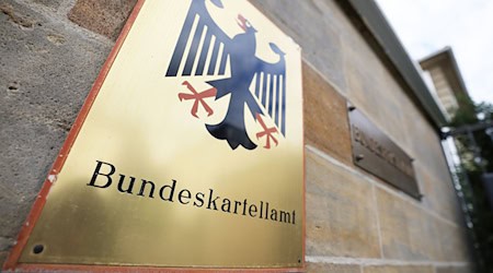 Ein Schild mit Bundesadler hängt vor dem Bundeskartellamt in Bonn. / Foto: Oliver Berg/dpa/Symbolbild