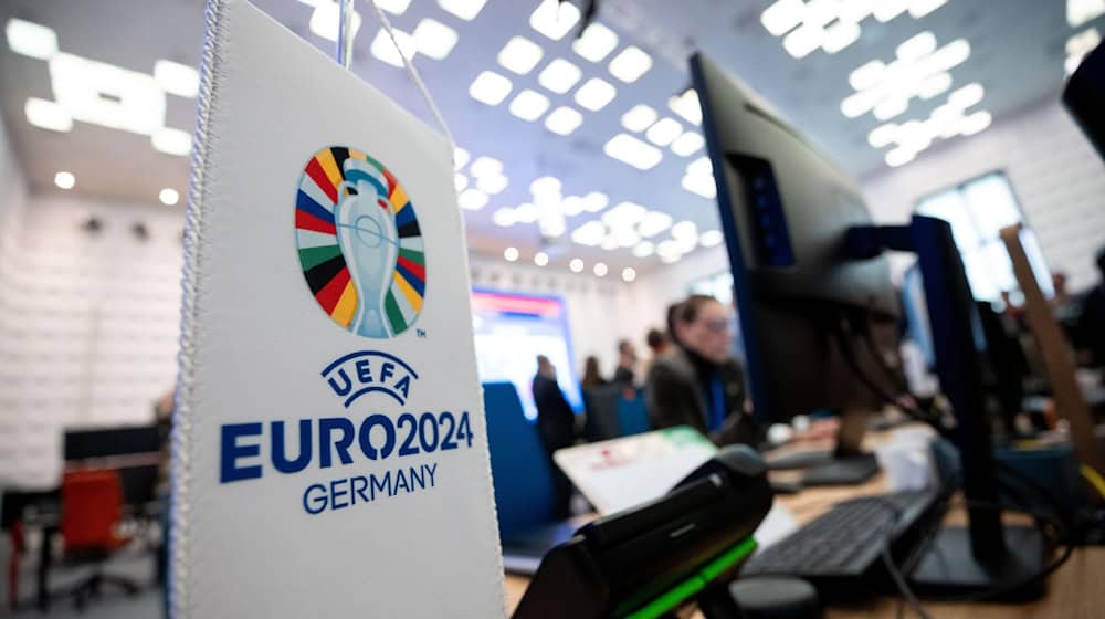 Das Logo der Euro 2024 auf einem Fähnchen steht an einem Arbeitsplatz. / Foto: Fabian Strauch/dpa/Symbolbild