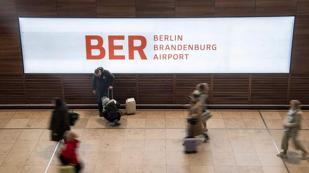 Reisende gehen durch das Terminal im Flughafen BER. / Foto: Paul Zinken/dpa