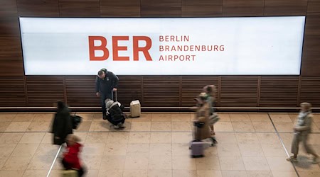 Reisende gehen durch das Terminal im Flughafen BER. / Foto: Paul Zinken/dpa