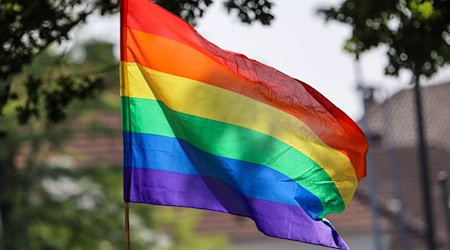 Eine Regenbogenfahne weht ei einem Umzug zum Christopher Street Day (CSD) im Wind. / Foto: Focke Strangmann/dpa/Archivbild