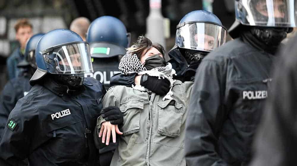 Eine der propalästinensischen Besetzerinnen des Instituts für Sozialwissenschaften der Berliner Humboldt-Universität (HU) wird von zwei Polizisten aus dem Gebäude gebracht. / Foto: Soeren Stache/dpa