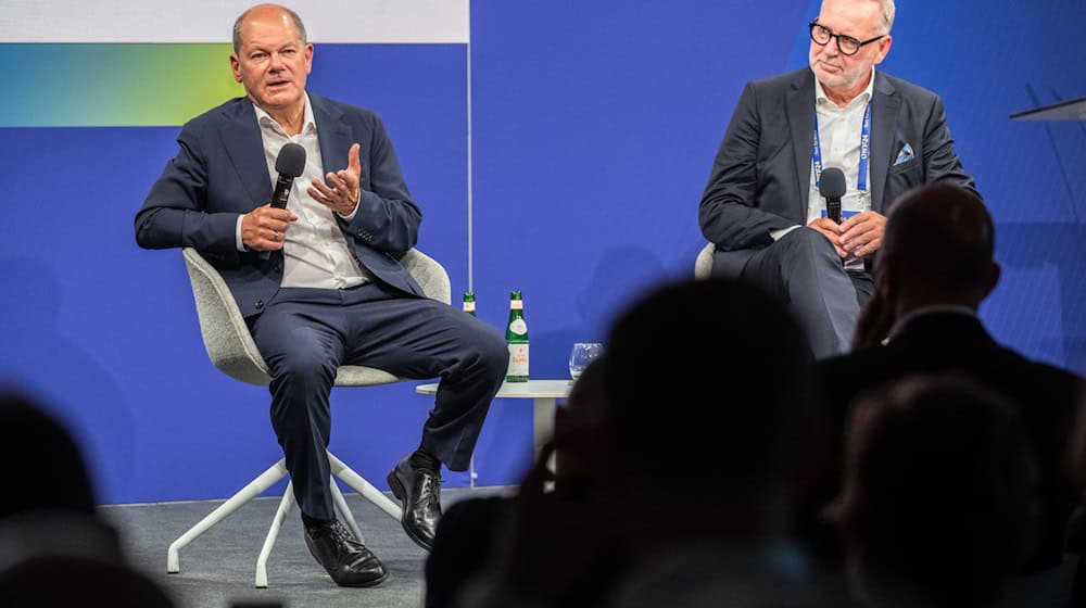 Bundeskanzler Olaf Scholz (l, SPD) und Frank Nehring, Präsident Ostdeutsches Wirtschaftsforum (OWF) sitzen beim Ostdeutschen Wirtschaftsforum im Theater am See auf der Bühne. / Foto: Monika Skolimowska/dpa