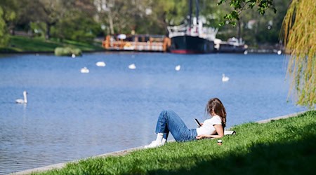 Eine Frau liegt am Landwehrkanal in der Sonne. / Foto: Annette Riedl/dpa/Symbolbild