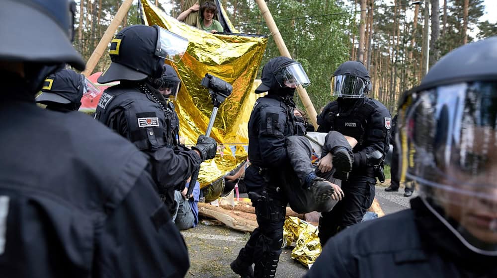 Polizei räumt Aktivisten von einer Straßenblockade bei einer Protestaktion gegen Tesla. / Foto: Michael Ukas/tnn/dpa