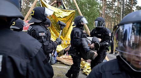 Polizei räumt Aktivisten von einer Straßenblockade bei einer Protestaktion gegen Tesla. / Foto: Michael Ukas/tnn/dpa