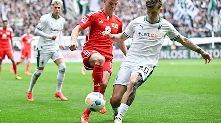 Mönchengladbachs Luca Netz (r) und Berlins Andras Schäfer kämpfen um den Ball. / Foto: Federico Gambarini/dpa