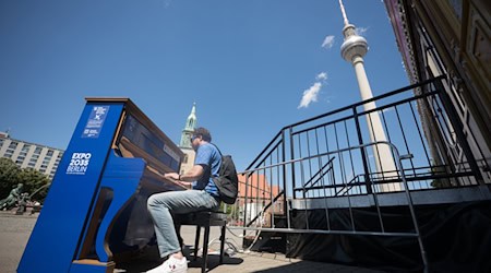 Ein Mann spielt das Global Goals Klavier Nr. 16: «Frieden, Gerechtigkeit und starke Institutionen», dass anlässlich der Europawahl in Deutschland in Sichtweite des Fernsehturms steht. / Foto: Sebastian Christoph Gollnow/dpa