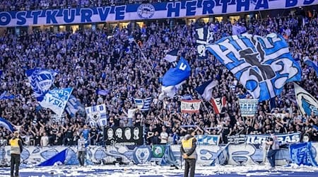 Fans von Hertha BSC feuern ihr Team aus der Ostkurve mit Fahnen an. / Foto: Andreas Gora/dpa/Symbolbild