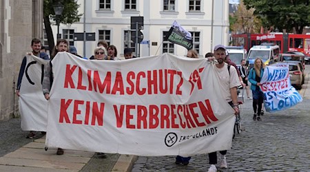 Klimaaktivisten protestieren vor der Gerichtsverhandlung in Cottbus. / Foto: Michael Bahlo/dpa