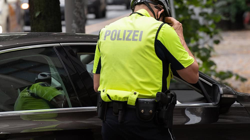 Ein Beamter der Fahrrad-Staffel der Berliner Polizei kontrolliert einen Pkw-Fahrer. (Symbolbild) / Foto: Paul Zinken/dpa