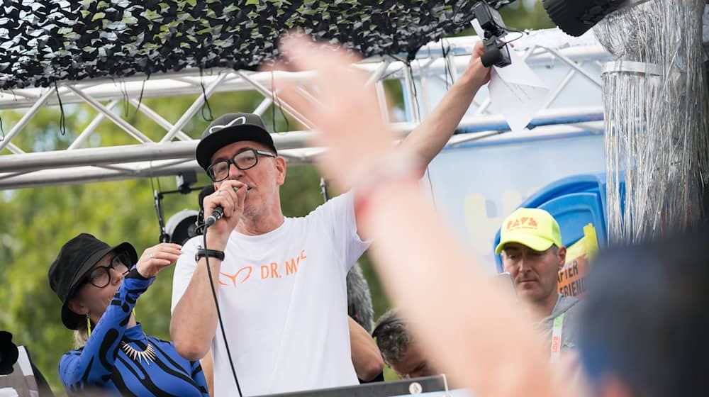 Dr. Motte, DJ und Mitgründer von «Rave the Planet», spricht zum Auftakt der Technoparade. / Foto: Sebastian Christoph Gollnow/dpa