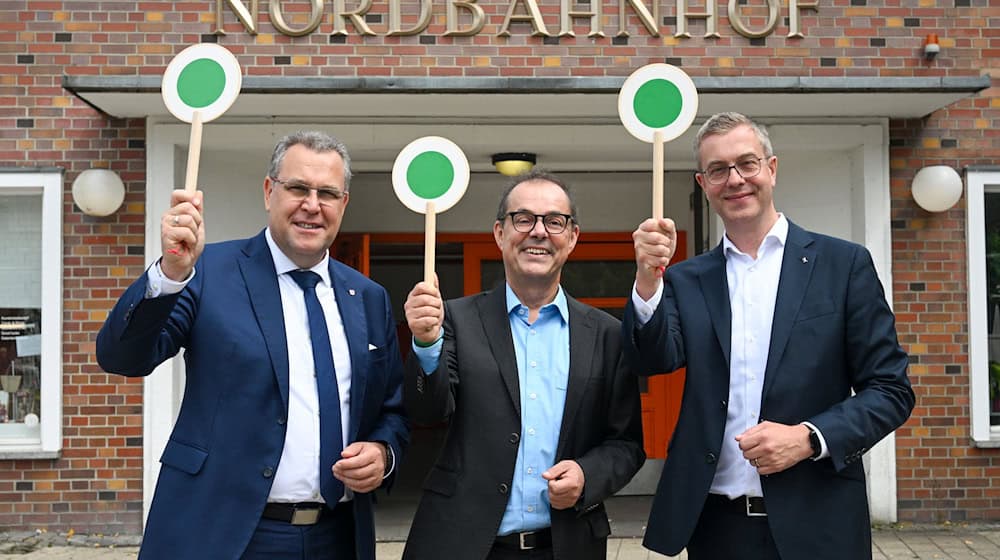 S-Bahnchef Peter Buchner (Mitte), Finanzsenator Stefan Evers (rechts) und Landesminister Rainer Genilke (links) geben grünes Licht zum 100. S-Bahn-Geburtstag.  / Foto: Jens Kalaene/dpa