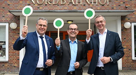 S-Bahnchef Peter Buchner (Mitte), Finanzsenator Stefan Evers (rechts) und Landesminister Rainer Genilke (links) geben grünes Licht zum 100. S-Bahn-Geburtstag.  / Foto: Jens Kalaene/dpa