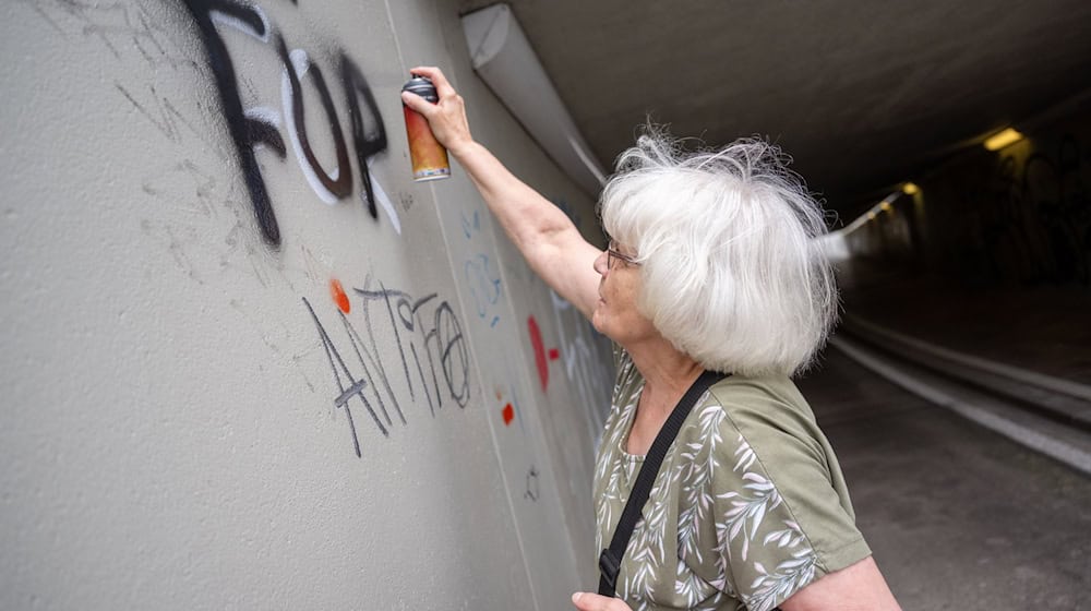 Kaum eine halbe Minute braucht Irmela Mensah-Schramm, um einen Schriftzug mit ihrer Spraydose zu überschreiben. / Foto: Christophe Gateau/dpa