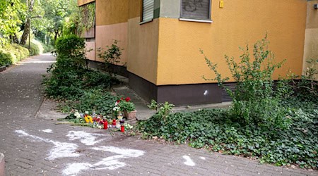 Kerzen und Blumen stehen und liegen in Berlin-Zehlendorf an dem Ort, an dem mutmaßlich ein Mann seine Ex-Frau erstochen haben soll. (Archivbild) / Foto: Fabian Sommer/dpa