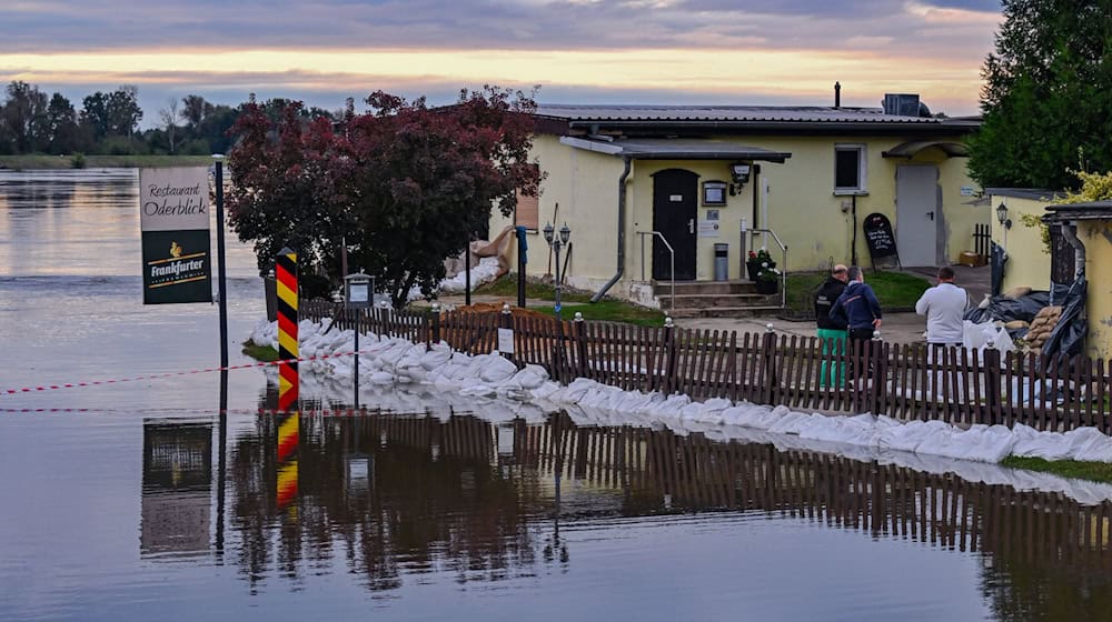 Das Wasser steht in Lebus direkt vor einem Restaurant, das mit Sandsäcken geschützt wird.  / Foto: Patrick Pleul/dpa