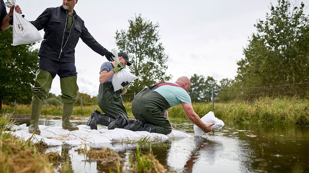 Durch einen Schutzdeich in Eisenhüttenstadt sickert Wasser. Einsatzkräfte rücken mit  Sandsäcken an. / Foto: Michael Ukas/dpa