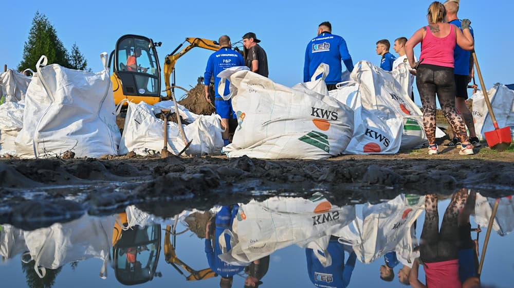 Einwohner von Lebus, einer Kleinstadt etwa zehn Kilometer nördlich von Frankfurt (Oder), befüllen Sandsäcke gegen das drohende Hochwasser vom deutsch-polnischen Grenzfluss Oder. / Foto: Patrick Pleul/dpa