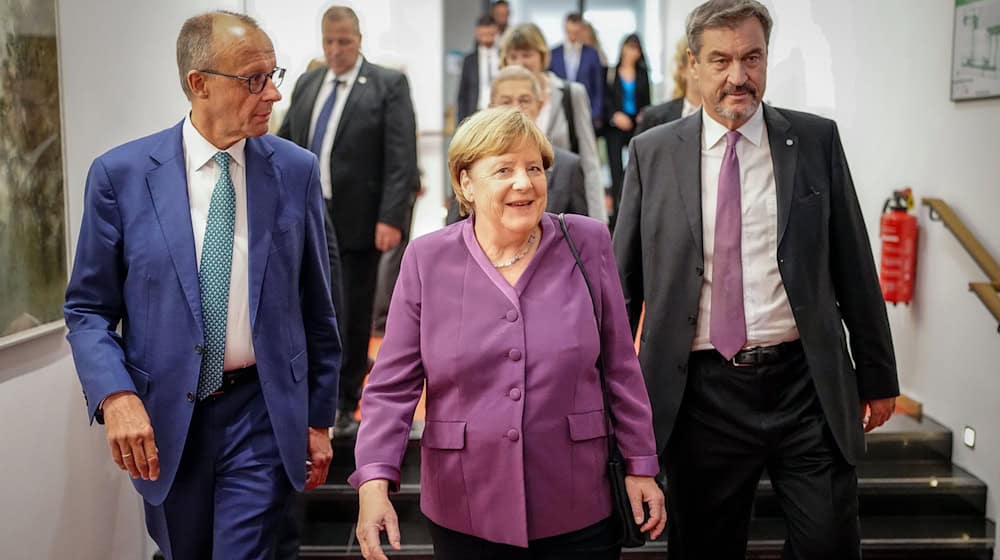 Markus Söder, CSU-Vorsitzender und Ministerpräsident von Bayern, und Friedrich Merz, CDU-Bundesvorsitzender und Unionsfraktionsvorsitzender, begleiteten Altkanzlerin Angela Merkel zu ihrem Platz. / Foto: Kay Nietfeld/dpa