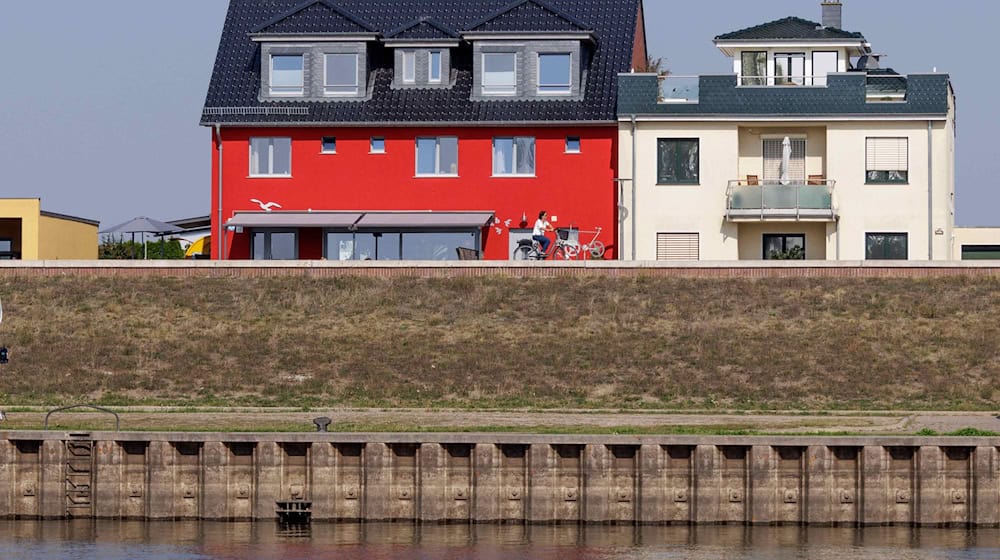 Wohnhäuser hinter dem Hochwasserschutz an der Elbe in Wittenberge. / Foto: Carsten Koall/dpa