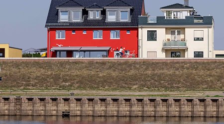 Wohnhäuser hinter dem Hochwasserschutz an der Elbe in Wittenberge. / Foto: Carsten Koall/dpa