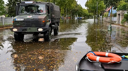 Mit einem Unimog sind Einsatzkräfte in Frankfurt (Oder) unterwegs, um Bewohner aus einer überfluteten Straße zu bringen. / Foto: Patrick Pleul/dpa