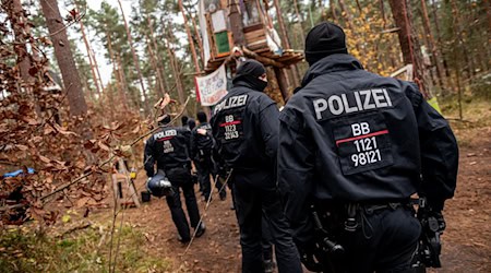 Polizeikräfte sperren ein Waldgebiet, in dem das Tesla-Protestcamp in Grünheide bei Berlin liegt. / Foto: Fabian Sommer/dpa