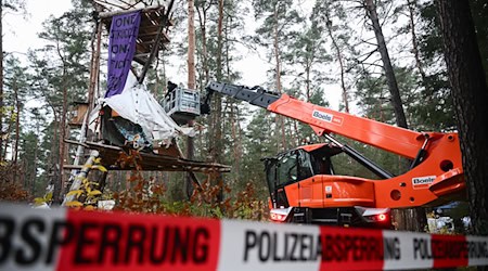 Mit Hilfe einer Hebebühne kommen die Polizeikräfte an die Baumhäuser im aufgelösten Tesla-Protestcamp heran.  / Foto: Sebastian Christoph Gollnow/dpa