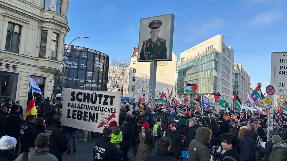 Neben Touristen versammeln sich diesmal auch Demonstranten am Checkpoint Charlie. / Foto: Marion van der Kraats/dpa