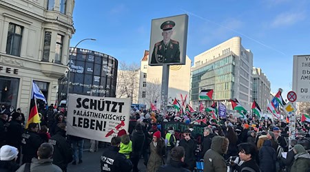 Neben Touristen versammeln sich diesmal auch Demonstranten am Checkpoint Charlie. / Foto: Marion van der Kraats/dpa