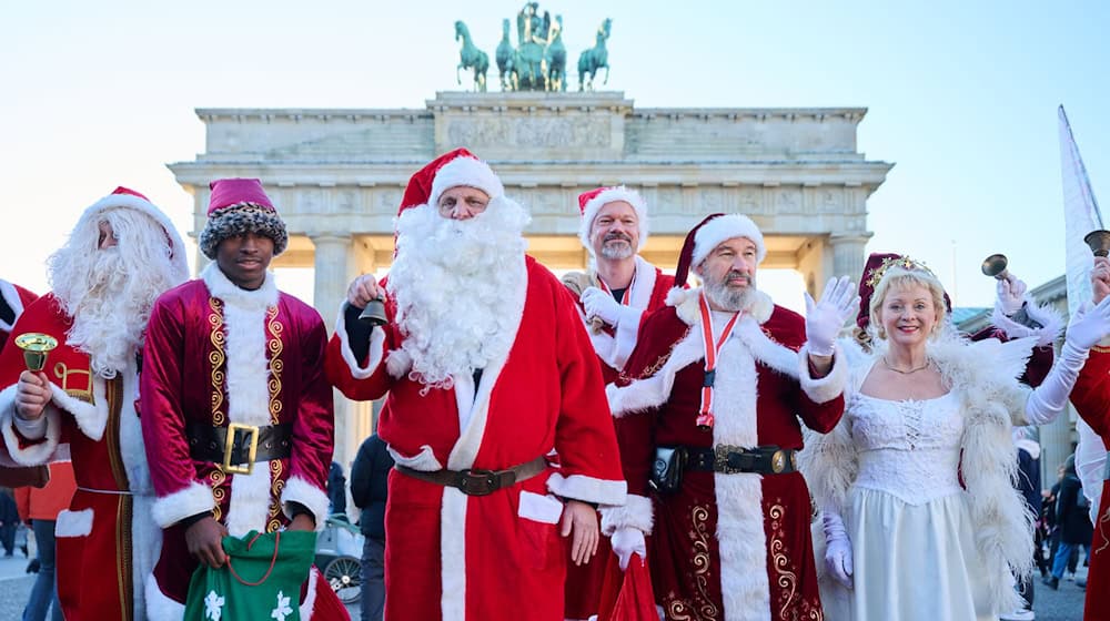 Roter Mantel, Bart und Geschenke: Weihnachtsmänner und Engel stimmen in Berlin auf die Weihnachtszeit ein.  / Foto: Annette Riedl/dpa