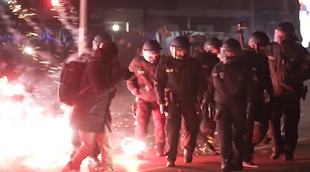 Polizisten stehen zwischen brennendem Feuerwerk in Neukölln. (Foto aktuell) / Foto: Julius Schreiner/dpa