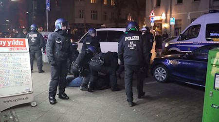 Polizisten nehmen in der Silvesternacht einen Menschen fest.  / Foto: Julius Schreiner/dpa