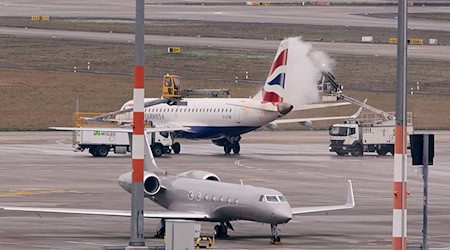 Ein Flugzeug wird am Flughafen BER vom Eis befreit. Der Hauptstadtflughafen begrenzt die Zahl der Ankünfte vorsorglich.  / Foto: Jörg Carstensen/dpa