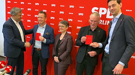 Die Berliner SPD mit Fraktionschef Raed Saleh (l) überreicht zwei neuen Mitgliedern ihr Parteibuch. / Foto: Stefan Kruse/dpa