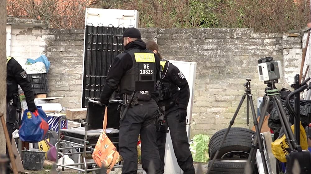 Polizisten durchsuchen ein Grundstück in Berlin-Wannsee.  / Foto: Sven Käuler/dpa