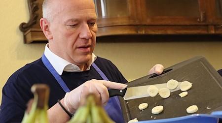 Der Regierende Bürgermeister Kai Wegner hilft beim Kochen für arme Menschen in der Wärmestube in Neukölln. / Foto: -/Ev. Kirchenkreis Neukölln/dpa