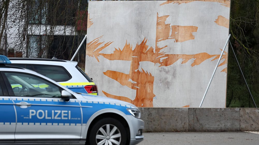 Ein Polizeiauto steht vor einem zerstörten Wahlplakat. (Archivbild) / Foto: Bernd Wüstneck/dpa