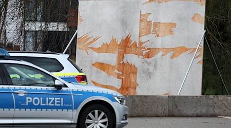 Ein Polizeiauto steht vor einem zerstörten Wahlplakat. (Archivbild) / Foto: Bernd Wüstneck/dpa