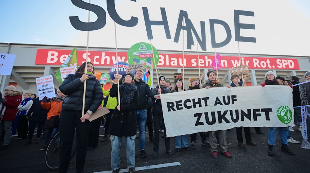 Zum Parteitag demonstrieren mehrere Menschen vor dem Gebäude.  / Foto: Sebastian Christoph Gollnow/dpa