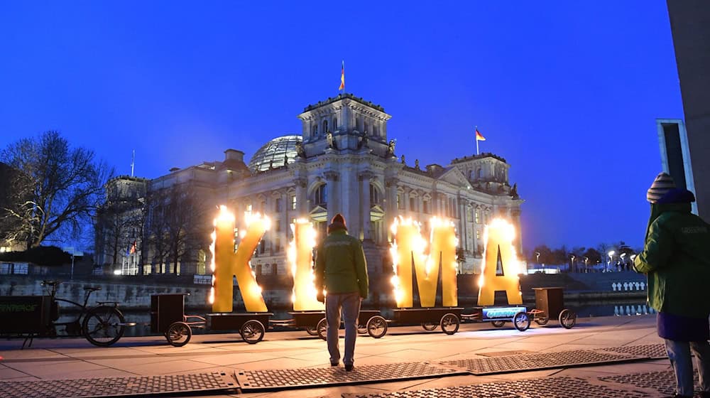 Greenpeace-Aktivisten demonstrieren gegenüber vom Reichstag. / Foto: Paul Zinken/dpa