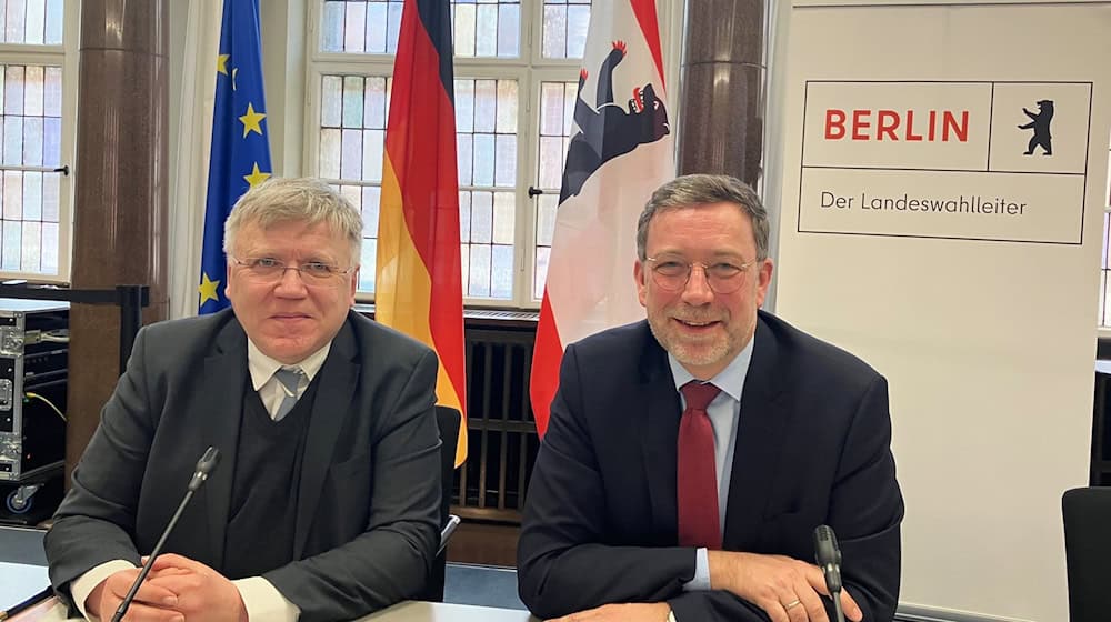 Landeswahlleiter Stephan Bröchler (links) und sein Stellvertreter Roland Brumberg sitzen an einem Tisch bei der Sitzung des Landeswahlausschusses im Roten Rathaus.  / Foto: Stefan Kruse/dpa