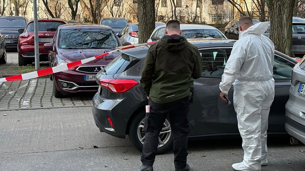Nach dem gewaltsamen Tod eines 88-Jährigen stehen zwei Beamte der Spurensicherung vor einem Auto, das mit Absperrband gesichert ist. (Archivbild) / Foto: Marco Porzig/Porzig/dpa