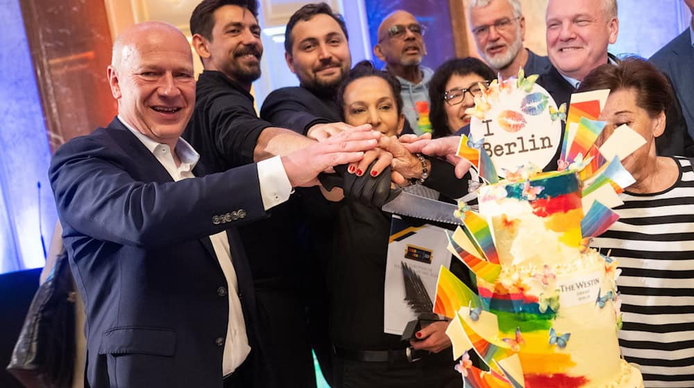 Die Regenbogentorte serviert die Initiative Maneo jedes Jahr im Mai. Kai Wegner (CDU, links) hat sie dieses Mal angeschnitten. / Foto: Christophe Gateau/dpa