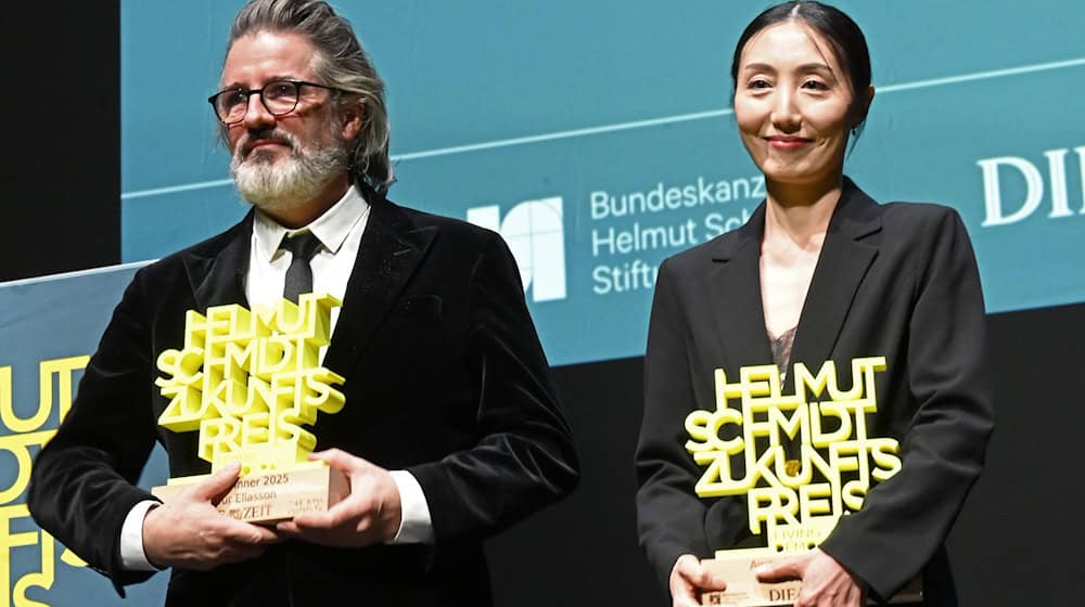 Olafur Eliasson und Hwanhee Hwang stehen mit dem Helmut-Schmidt-Zukunftspreis auf der Bühne im Hamburger Thalia Theater. / Foto: David Hammersen/dpa