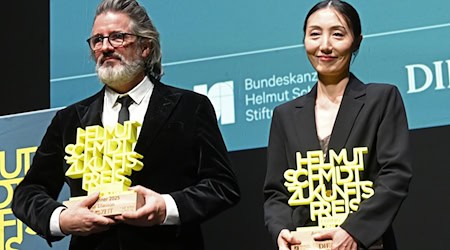 Olafur Eliasson und Hwanhee Hwang stehen mit dem Helmut-Schmidt-Zukunftspreis auf der Bühne im Hamburger Thalia Theater. / Foto: David Hammersen/dpa