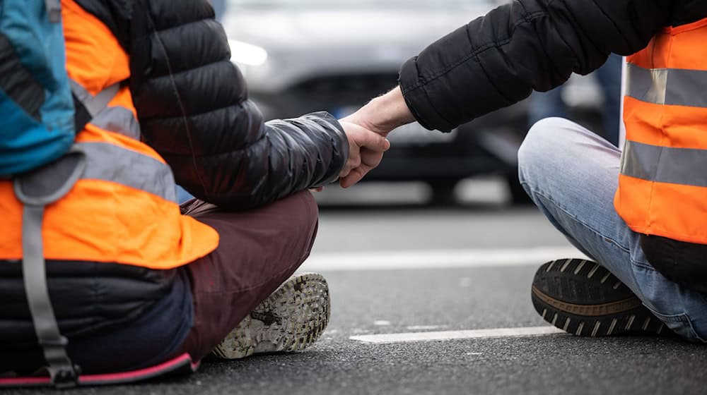Klimaaktivisten der Klima-Gruppe Letzte Generation blockieren eine Straße. Die Gruppe nennt sich inzwischen Neue Generation. (Archivbild)  / Foto: Bernd Thissen/dpa