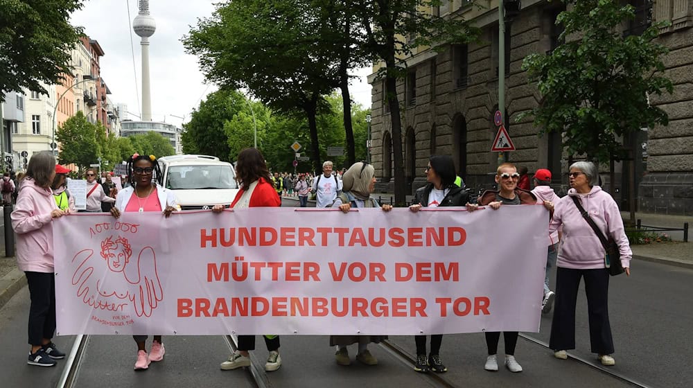 Demonstrantinnen und Demonstranten fordern mehr Unterstützung für Mütter.  / Foto: Paul Zinken/dpa