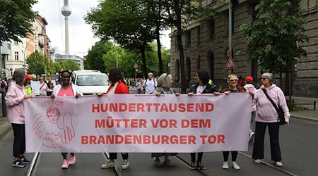 Demonstrantinnen und Demonstranten fordern mehr Unterstützung für Mütter.  / Foto: Paul Zinken/dpa